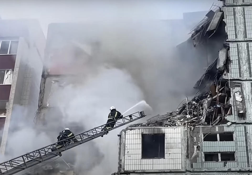 In this image taken from video provided by the National Police of Ukraine, firefighters work at an apartment building destroyed by a Russian attack in the town of Uman, around 215 kilometers (134 miles) south of Kyiv, Friday, April 28, 2023. (National Police of Ukraine via AP)
