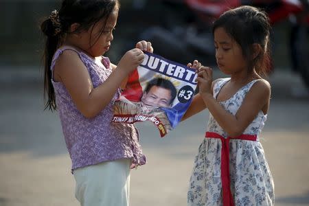 Girls play with a campaign poster of presidential candidate Rodrigo "Digong" Duterte during election campaigning for May 2016 national elections in Malabon, Metro Manila in the Philippines April 27, 2016. REUTERS/Erik De Castro