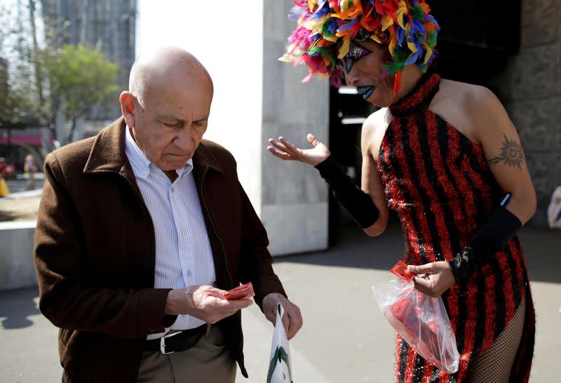 Polo Gomez, also known as drag queen Yolanda la del Rio, from organization Condomovil A.C., gives out a free condom to a man during an event organized by AIDS Healthcare Foundation for the International Condom Day, in Mexico City