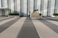 A United Nations Security officer walks past the The Knotted Gun" by Swedish sculpture Carl Fredrik Reutersward during the 75th session of the United Nations General Assembly, Tuesday, Sept. 22, 2020, at U.N. headquarters. This year's annual gathering of world leaders at U.N. headquarters will be almost entirely "virtual." Leaders have been asked to pre-record their speeches, which will be shown in the General Assembly chamber, where each of the 193 U.N. member nations are allowed to have one diplomat present. (AP Photo/Mary Altaffer)