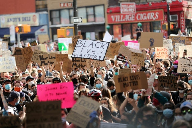 FILE PHOTO: Protesters hold placards as they rally against the death in Minneapolis police custody of George Floyd, in the Manhattan borough of New York City, U.S., June 2, 2020. REUTERS/Jeenah Moon/File Photo