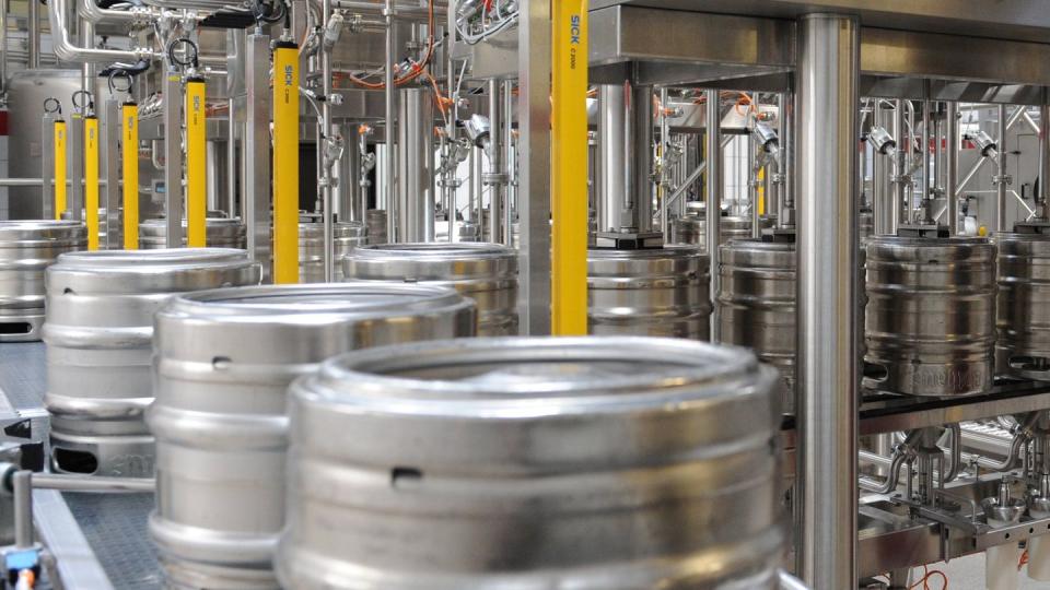 Bier wird in einer Brauerei in Fässer gefüllt.