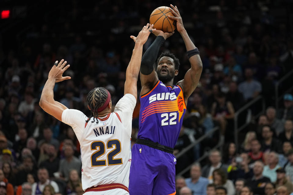 Phoenix Suns center Deandre Ayton, right, shoots over Denver Nuggets forward Zeke Nnaji during the second half of an NBA basketball game, Friday, March 31, 2023, in Phoenix. (AP Photo/Matt York)