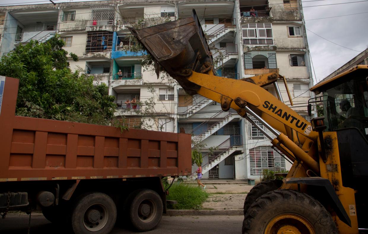 A worker operates a tractor shovel to clear debris in the wake of Hurricane Ian in Havana, Cuba, Wednesday, Sept. 28, 2022. 