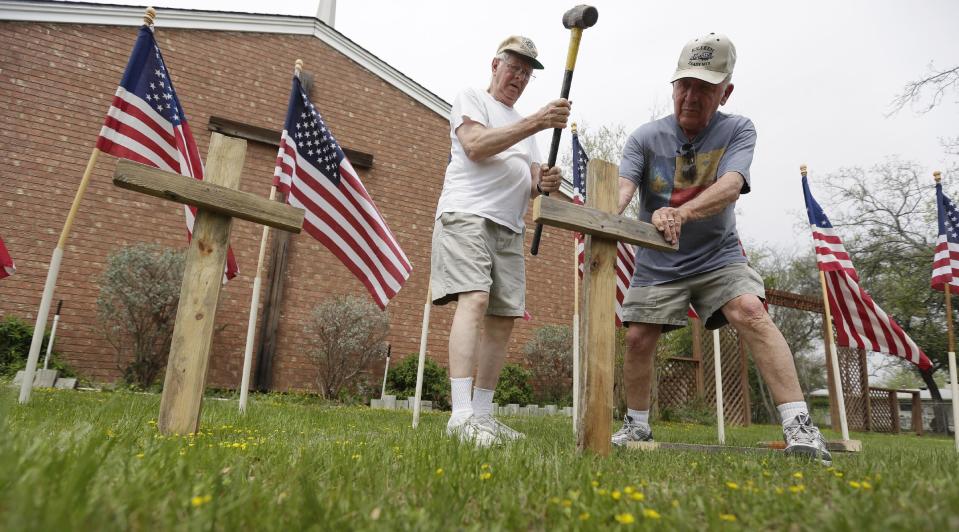 Bob Butler, left, and Bob Gordon, right, work on a memorial at Central Christian Church for the victims of a Fort Hood shooting, Thursday, April 3, 2014, in Killeen, Texas. A soldier, Spc. Ivan Lopez, opened fire Wednesday on fellow service members at the Fort Hood military base, killing three people and wounding 16 before committing suicide. (AP Photo/Eric Gay)