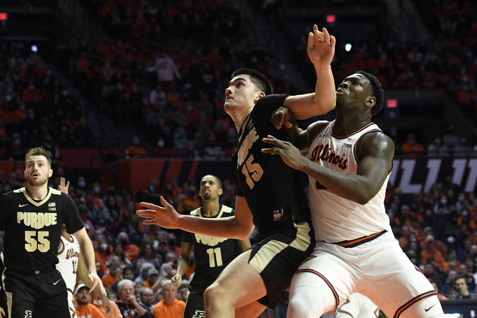 Purdue's Zach Edey (15) and Illinois' Kofi Cockburn vie for position under the basket during the first half of an NCAA college basketball game Monday, Jan. 17, 2022, in Champaign, Ill. (AP Photo/Michael Allio)