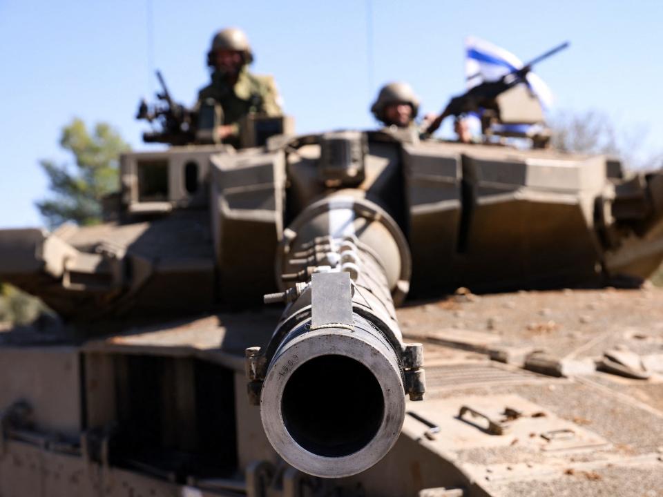 Israeli soldiers sit on a Merkava tank as they man a position at an undisclosed location on the border with Lebanon on October 21, 2023.