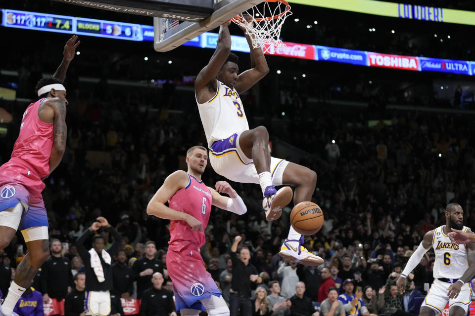 Los Angeles Lakers' Thomas Bryant (31) clings to the rim after dunking against the Washington Wizards during the second half of an NBA basketball game, Sunday, Dec. 18, 2022, in Los Angeles. The Lakers won 119-117. (AP Photo/Jae C. Hong)