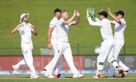 Cricket - Pakistan v England - First Test - Zayed Cricket Stadium, Abu Dhabi, United Arab Emirates - 13/10/15 England's Ben Stokes celebrates with team mates after taking the wicket of Pakistan's Mohammad Hafeez (not pictured) Action Images via Reuters / Jason O'Brien Livepic