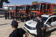 Romanian firefighters stand in front of fire engines during a ceremony, in Athens, on Saturday, July 2, 2022. Twenty eight Romanian firefighters, the first of more than 200 firefighters from other European countries that will help their Greek colleagues in fighting wildfires, were welcomed by Climate Crisis and Civil Protection Minister Christos Stylianides and the leadership of Greece's Fire Service. (AP Photo/Yorgos Karahalis)