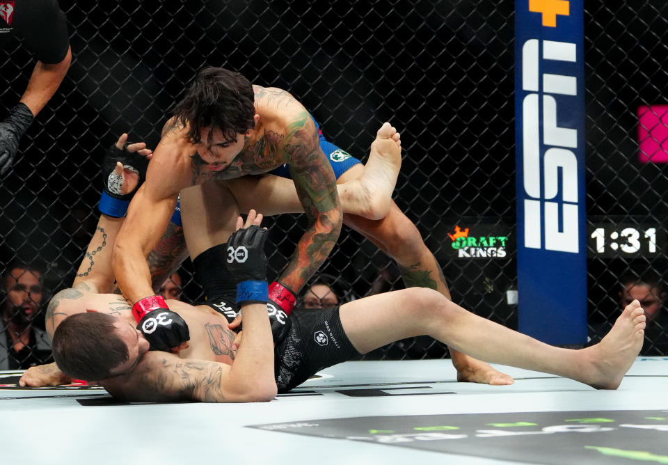 Dec 16, 2023; Las Vegas, Nevada, USA; Andre Fili (red gloves) fights Lucas Almeida (blue gloves) during UFC 296 at T-Mobile Arena. Mandatory Credit: Stephen R. Sylvanie-USA TODAY Sports