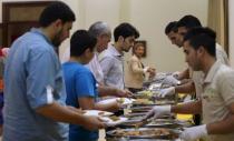 Palestinians fill dishes with food as they gather for Iftar, the nightly breaking of the Ramadan fast, at the Roots hotel in Gaza City July 2, 2015. REUTERS/Mohammed Salem