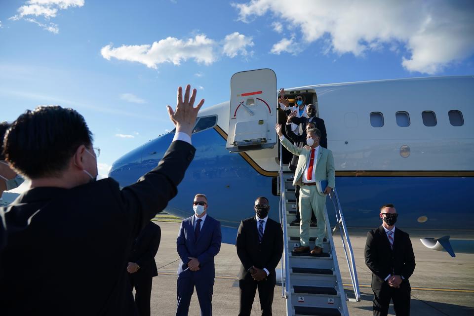 In this photo released by Taiwan's Ministry of Foreign Affairs, House Speaker Nancy Pelosi, top, and other members of her delegation wave as they prepare to leave Taipei, Taiwan, Wednesday, Aug. 3, 2022.