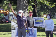 Fifth Congressional District Democratic candidate Antone Melton-Meaux, left, waves to passing cars in south Minneapolis Tuesday, Aug. 11, 2020, primary Election Day in Minnesota. He faces Democratic, Rep. Ilhan Omar in the primary. (AP Photo/Jim Mone)