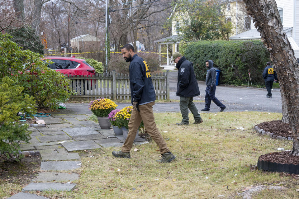 Local and federal police and fire officials comb the neighborhood near the scene of a house explosion looking for evidence on Tuesday, Dec. 5, 2023, in Arlington, Va. (AP Photo/Kevin Wolf)