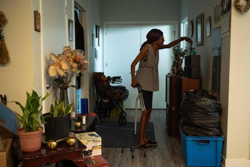 Vivian Jackson adjusts an image of her daughter at her apartment on June 15 in Kansas City. Due to a stroke and the falls she has had in her apartment, Jackson suffers from constant pain and limited mobility. Zachary Linhares/zlinahres@kcstar.com