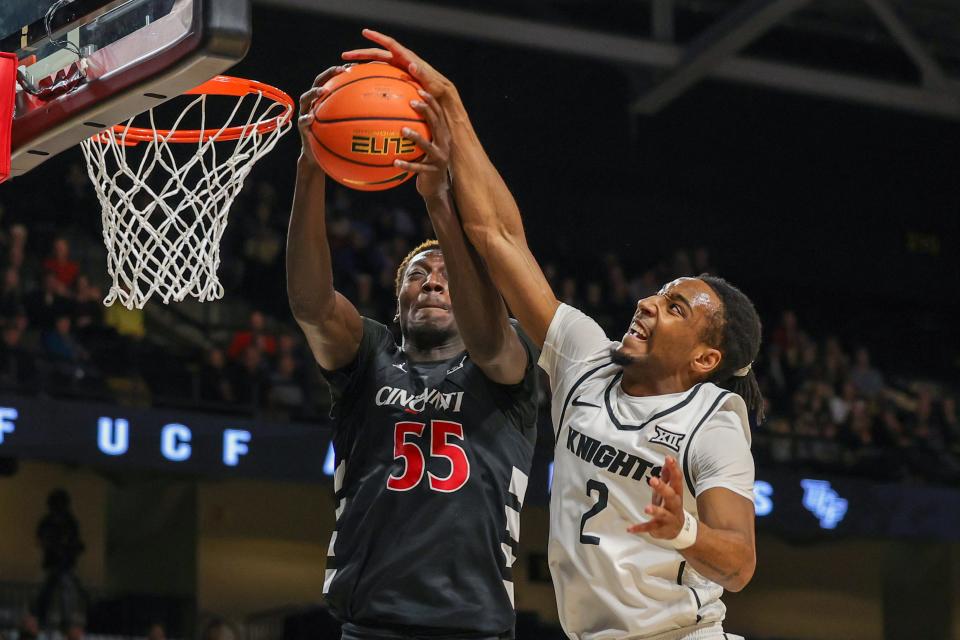 Cincinnati Bearcats forward Aziz Bandaogo (55) and UCF Knights guard Shemarri Allen (2) battle for the rebound Saturday. UC outrebounded the Knights 46-33 and defeated UCF 76-74.