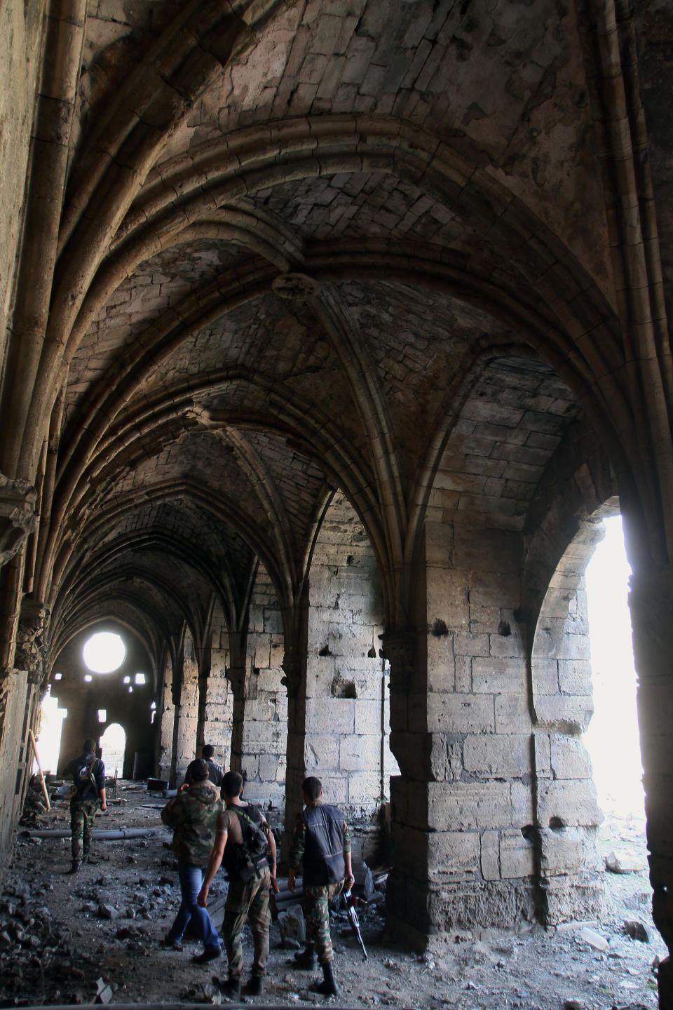 Syrian troops walk on a corridor of the Crac des Chevaliers as they take reporters on a tour a day after Syrian troops ousted rebels from the castle located near the village of Hosn, Syria, Friday, March 21, 2014. The Syrian army ousted rebels from the massive Crusader fortress after several hours of fierce fighting, killing at least 93 of them as they fled to neighboring Lebanon, an army commander told reporters on a government-led tour of the area Friday. (AP Photo)