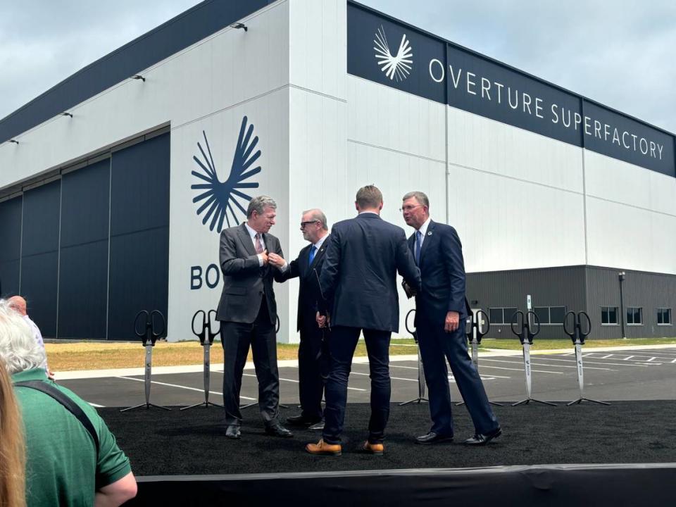 Gov. Roy Cooper (left) greets North Carolina Senate leader Phil Berger after they helped cut the ceremonial ribbon on Boom Supersonic’s jet factory at the Piedmont Triad International Airport in Greensboro on June 17, 2024.
