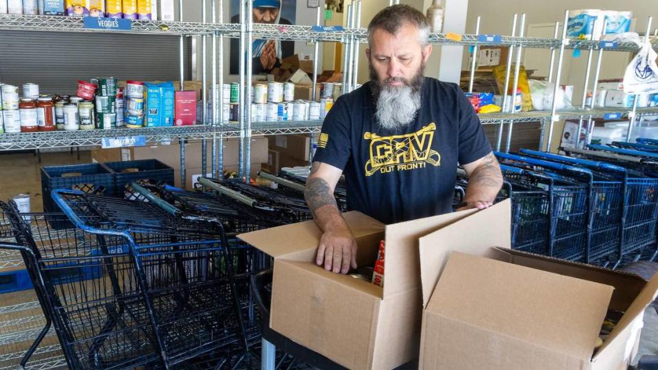 Brandon Weast, manager at the St. Vincent de Paul Overland Food Pantry, on Thursday puts together boxes of food for the next distribution day.