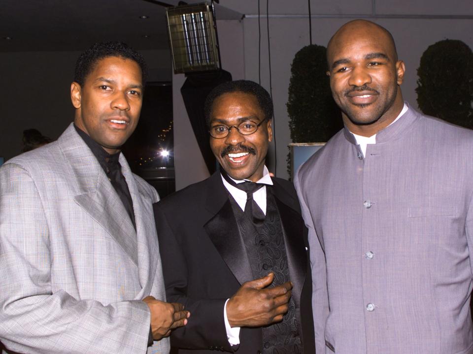 Rubin "Hurricane" Carter (C) poses with actor Denzel Washington (L) and boxing champion Evander Holyfield at the premier of the film "The Hurricane" in this file photo taken in Los Angeles December 14, 1999. Carter died on April 20, 2014, in Toronto after a battle with prostate cancer. He was 76. REUTERS/Fred Prouser/Files (UNITED STATES - Tags: ENTERTAINMENT SPORT OBITUARY)