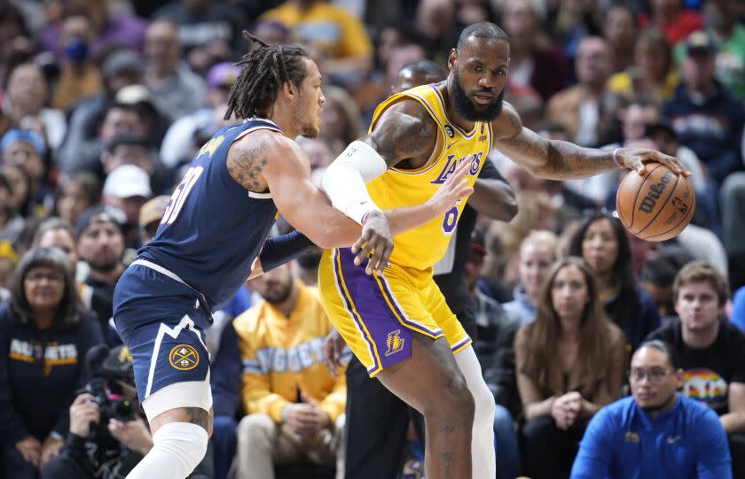 Los Angeles Lakers forward LeBron James, right, looks to pass the ball as Denver Nuggets forward Aaron Gordon.