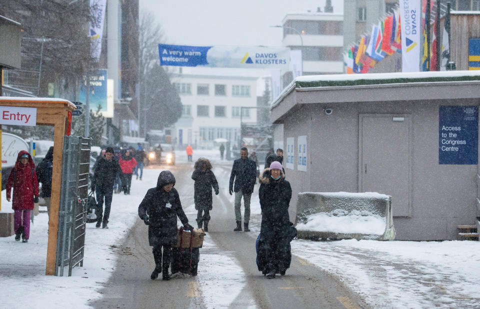 People walk during snowfall on the Promenade road, ahead of the World Economic Forum (WEF) 2023 in the Alpine resort of Davos, Switzerland, January 15, 2023. REUTERS/Arnd Wiegmann