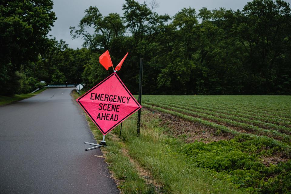 An emergency scene sign warning motorists approaching the River Hill Road bridge can be seen as rescue personnel work to recover the body of Keith Edward Schlabach on Tuesday near Port Washington. The man went missing early Saturday morning after his canoe capsized. His 27-year-old friend was able to swim ashore and call 911.