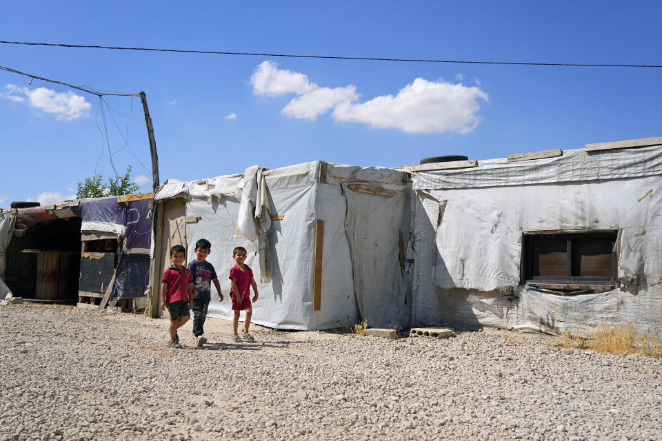 Syrian children walk past their family tents at a refugee camp in the town of Bar Elias, in Lebanon's Bekaa Valley, Tuesday, June 13, 2023. Aid agencies are yet again struggling to draw the world's attention back to Syria in a two-day donor conference hosted by the European Union in Brussels for humanitarian aid to Syrians that begins Wednesday. Funding from the conference also goes toward providing aid to some 5.7 million Syrian refugees living in neighboring countries, particularly Turkey, Lebanon and Jordan. (AP Photo/Bilal Hussein)