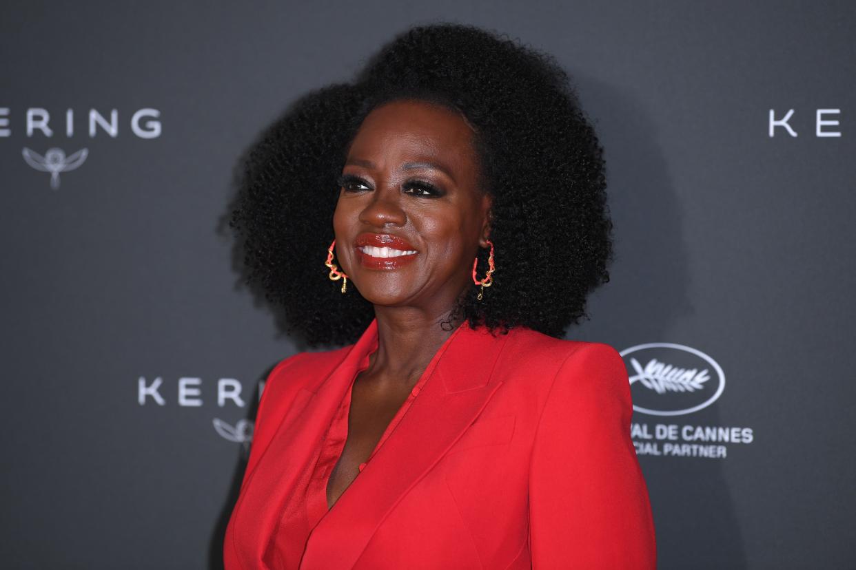 Viola Davis smiles in red lipstick and a red suit