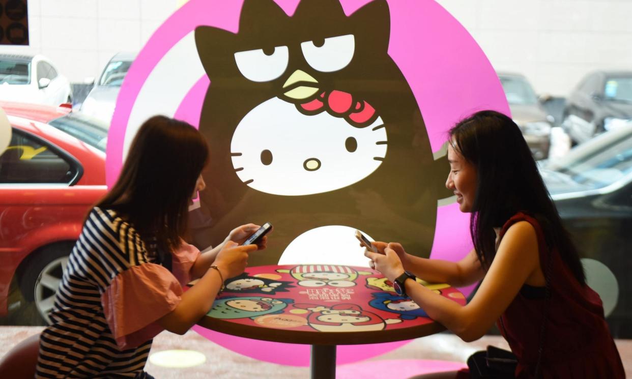 <span>‘An incredibly popular IP’ … patrons of a Hello Kitty theme restaurant, possibly playing the 2023 iOS hit Hello Kitty Island Adventure.</span><span>Photograph: VCG/Getty Images</span>