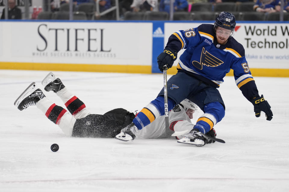 St. Louis Blues' Hugh McGing (56) is tripped up by Ottawa Senators' Vladimir Tarasenko, left, during the second period of an NHL hockey game Thursday, Dec. 14, 2023, in St. Louis. (AP Photo/Jeff Roberson)