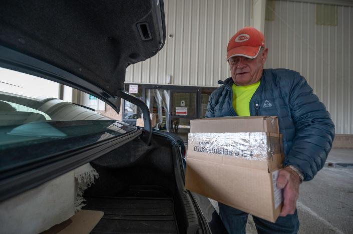 Volunteer Mark Holmes loads boxes of food into the car of a senior as part of Pueblo County&#39;s commodities distribution program on Tuesday, March 22, 2022.