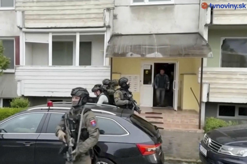 Police escort a man into a car, center right, believed to be the suspect for Wednesday's assassination attempt on Slovak Prime Minister Robert Fico from his home in Levice, Slovakia, Friday, May 17, 2024. Fico, 59, was attacked as he was greeting supporters after a government meeting in the former coal mining town of Handlova. Prosecutors have told police not to publicly identify the suspect and other details about the case. (TVNoviny via AP)