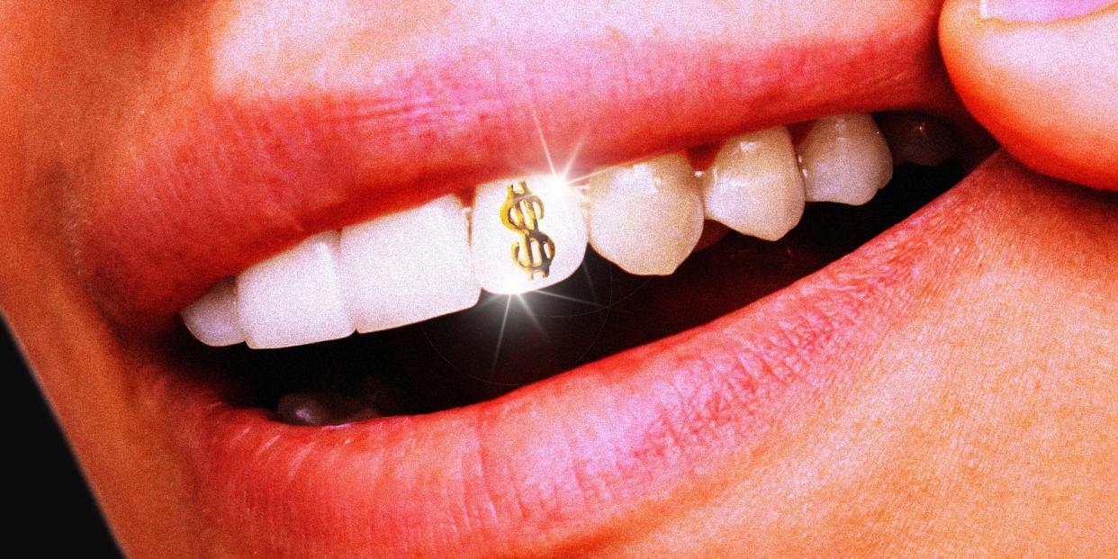 A person showing their teeth revealing a dollar sign tooth gem