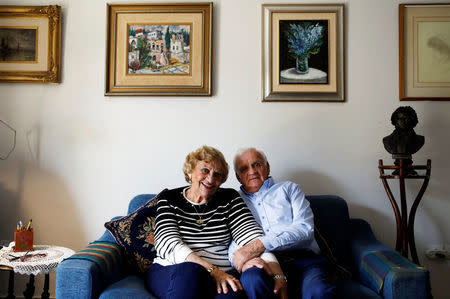 Aviva Ephrati (L), 84, retired kindergarten teacher, and Israel Ephrati, 87, retired supervisor at a higher educational institution, sit in the living room at the protective housing in Kfar Saba, north of Tel Aviv, Israel, February 8, 2018. The couple managed an art gallery in Haifa for some years. They've been married for 64 years. "In 1950 I met Israel by accident, who was a soldier then, when I was trying to push away another young man who wanted to date me which I didn't want during an evening out in Jerusalem. After that young man left the scene, Israel asked me to date him and I refused, I was willing to be a friend of him but I didn't want anything romantic. In the next four years, I almost got married to another guy who disappeared two weeks before the wedding after his father gave him an ultimatum after finding out that my father was not originally Jewish. During these years Israel kept on sending me letters for New Year and checking on me. It took four years, until I showed a friend these letters, which I still keep, who told me that I am stupid not to get on with him. We are married for 64 years now, we have three children and few months ago we got our first great grand daughter," said Aviva. REUTERS/Nir Elias