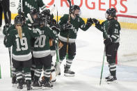 Boston defenseman Emily Brown, second from right, bumps fists with forward Alina Muller, right, while celebrating with teammates after their victory over Minnesota in Game 1 of a PWHL hockey championship series, Sunday, May 19, 2024, in Lowell, Mass. (AP Photo/Steven Senne)