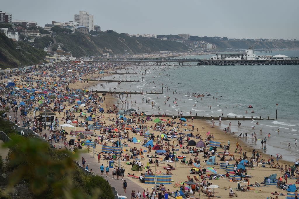 Beachgoers enjoy the sunshine as they sunbathe and play in the sea on Bournemouth beach: Getty Images