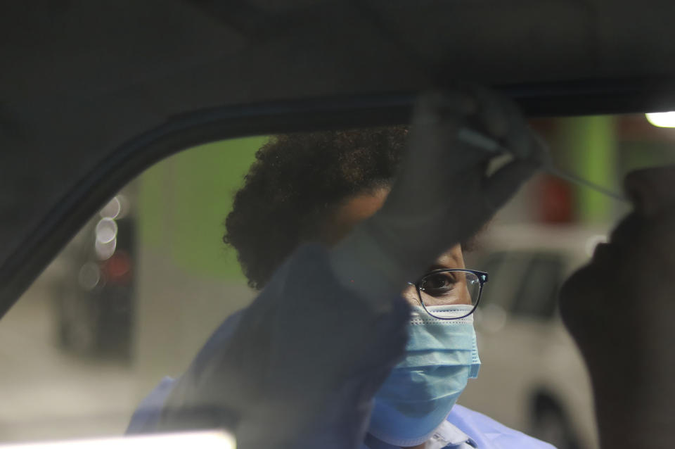 A health-care worker takes a nasal swab for COVID-19 testing at a Dis-Chem drive-through testing station at the V&A Waterfront in Cape Town, South Africa, Friday, Jan. 8, 2021. South Africa with 60 million people has reported by far the most cases of the coronavirus in Africa, with more than 1.1 million confirmed infections. (AP Photo/Nardus Engelbrecht)