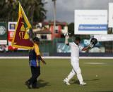 Sri Lanka's Kumar Sangakkara (R) waves his bat at fans as he walks off the field after his dismissal during the fourth day of their second test cricket match against India in Colombo August 23, 2015. REUTERS/Dinuka Liyanawatte