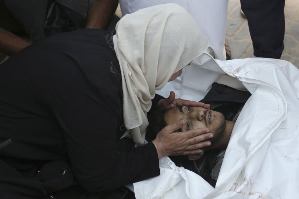 A Palestinian woman takes a last look at a loved one killed by Israeli bombardment, before his burial in Khan Younis, southern Gaza Strip, Friday, June 21, 2024. (AP Photo /Jehad Alshrafi)