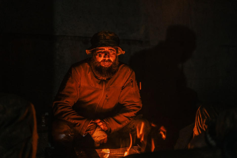 A Ukrainian soldier sits near a fire at the Azovstal steel plant to stay warm. (Courtesy Lt. Ilya Samoilenko)