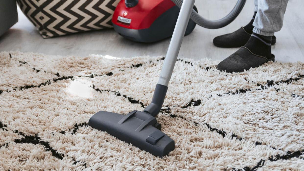 A man vacuuming carpet