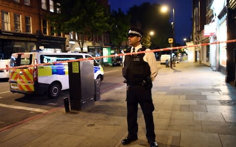 A police officer at the scene on Upper Street in Islington, north London, close to where a man was stabbed to death - Credit: Victoria Jones/PA