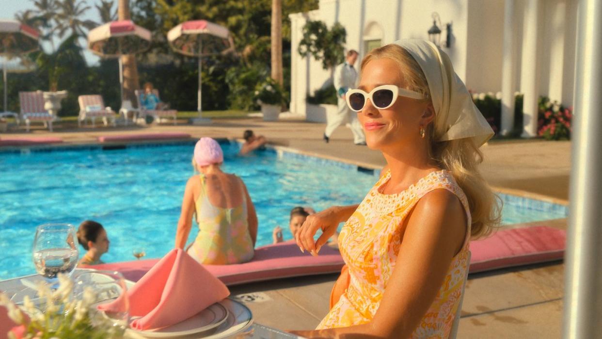 a woman in a garment by a pool with people in the background