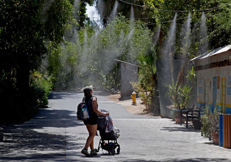 Visitors keep cool under misters at the Phoenix Zoo on July 16, 2019, in Phoenix.