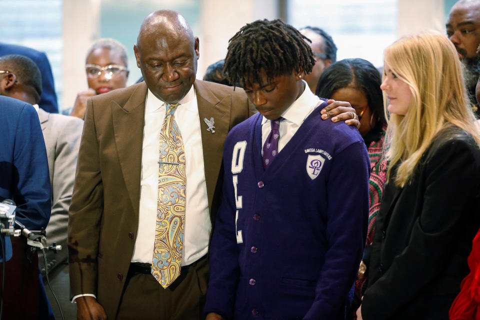 Civil rights attorney Ben Crump stands with his arm around Elijah Edwards, a student at Sail High School.