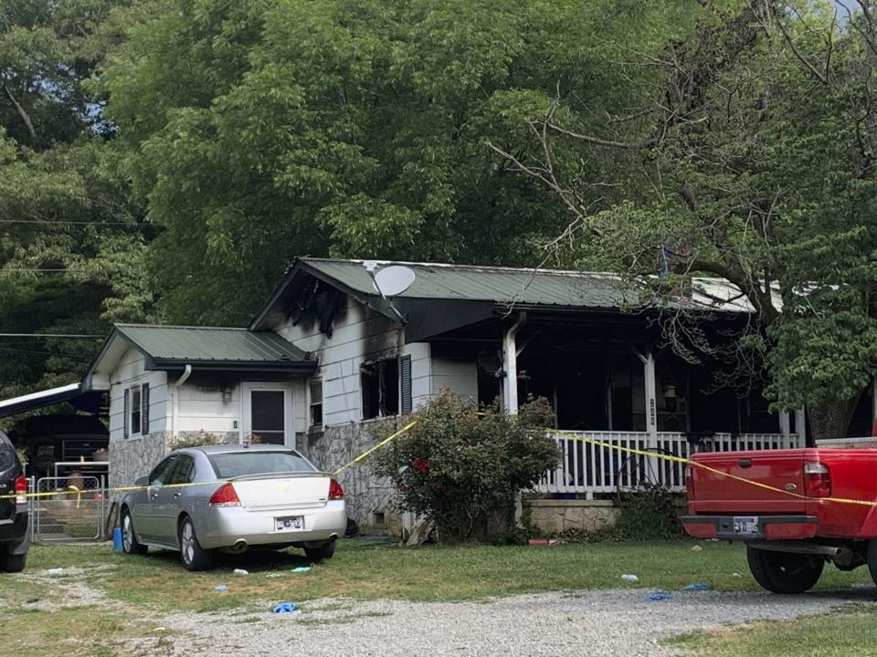 Police tape blocks off a home in Sequatchie, Tenn., Friday, June 16, 2023. Six people including three children were found dead in the Tennessee home where police responded to a shooting and arrived to find the residence ablaze, Thursday night June 15, authorities said. (Ellen Gerst/Chattanooga Times Free Press via AP)