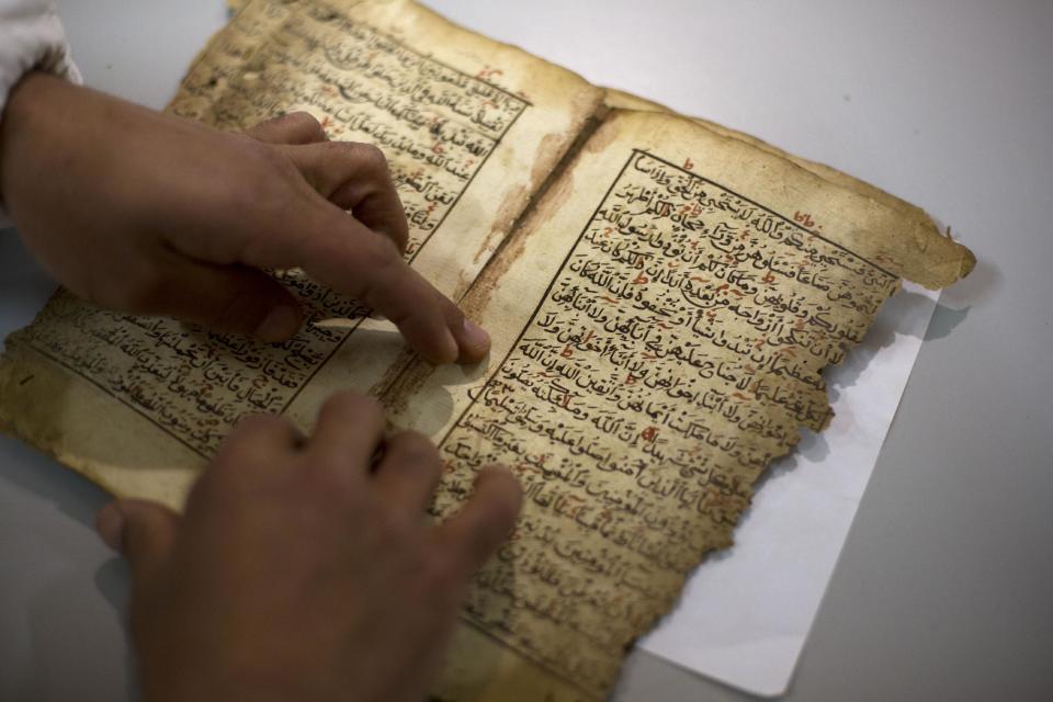 In this photo taken on Monday, Jan. 27, 2014, an employee works on a restoration of an old manuscript at the al-Aqsa mosque compound library in Jerusalem. The library has a collection of some 4,000 old manuscripts with about a quarter considered in poor condition. Half of the books are already undergoing restoration funded by the Waqf, Jordan’s Islamic authority which manages the holy site, and with assistance from UNESCO. (AP Photo/Dusan Vranic)