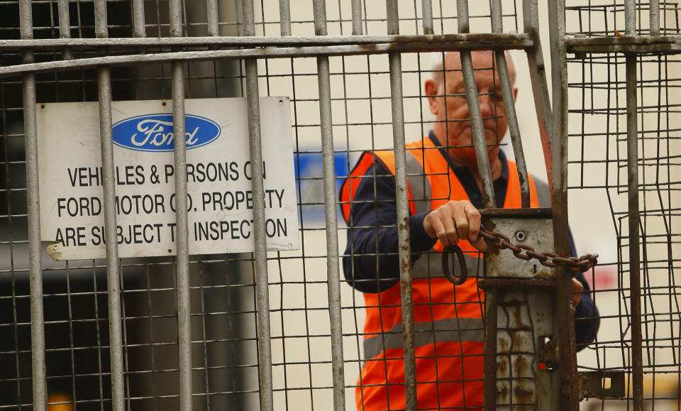 A security guard locks a gate after workers left the Ford Transit Assembly Plant in Southampton, England after being told that the site will close with the loss of up to 1,500 jobs Thursday Oct. 25, 2012. Ford, which expects to lose more than $1 billion a year in Europe, has been pursuing plant closures and layoffs. Fears were mounting that the axe may also soon fall in Britain as trade unions at Ford's Southampton plant have been called in for a meeting with management on Thursday. (AP Photo/Chris Ison/PA) UNITED KINGDOM OUT
